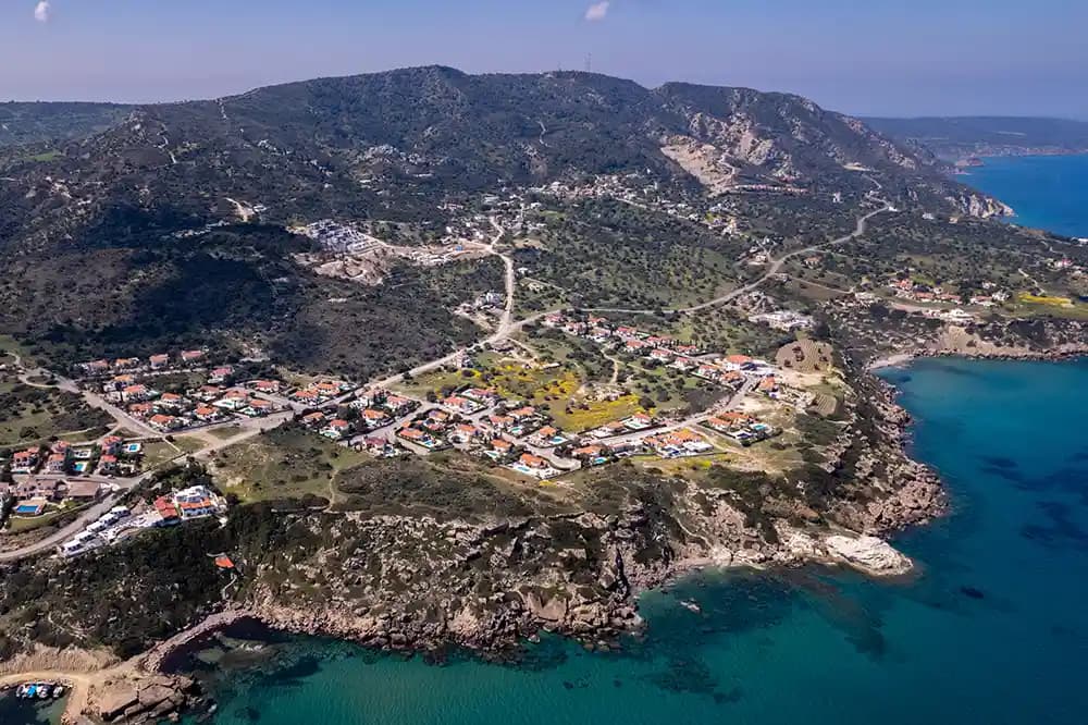 Luftaufnahme einer Küstensiedlung zwischen Bergen und Meer